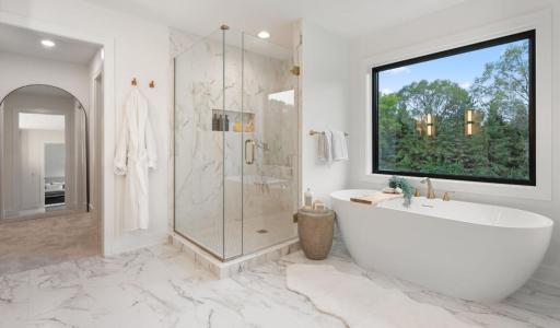 Tranquil Primary bath is spa inspired with custom tile, quartz countertops, free standing tub, oversized shower, dual vanities and large window overlooking private rear yard.