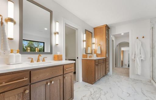 Tranquil Primary bath is spa inspired with custom tile, quartz countertops, free standing tub, oversized shower, dual vanities and large window overlooking private rear yard.