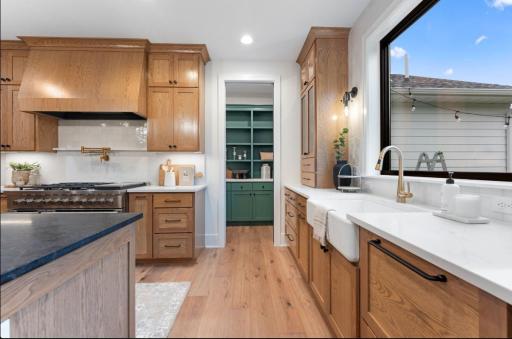 Chefs kitchen features designer wood hood, professional range and rear prep pantry.