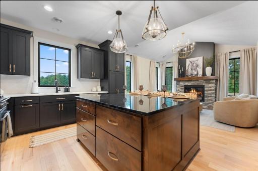 Designer ADU on main level shares four car garage includes a private entry, deluxe kitchen with custom cabinetry, large island with eating space, vaulted great room with fireplace and large windows.