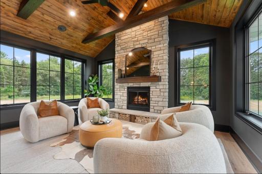 Main level sunroom is is vaulted with wood tongue and groove ceiling , beams, and wood burning fireplace with stone to ceiling.