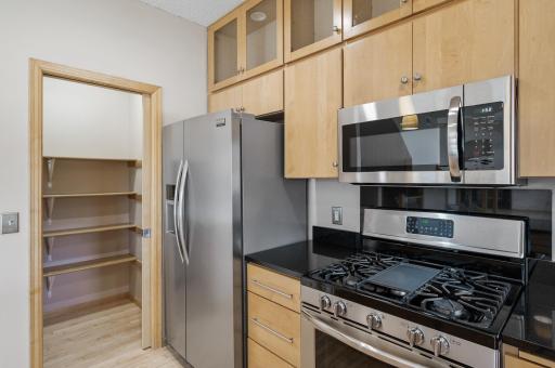 A spacious pantry with sturdy wood shelves offers ample storage and a touch of natural charm.