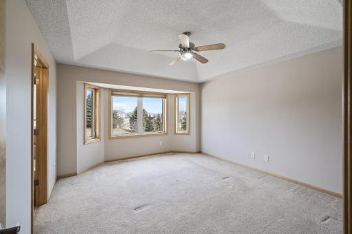 The upper level primary bedroom boasts with bay windows.