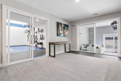 Double doors into the sport court on the left and golf simulator room on the right