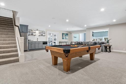 Additional kitchen area on lower level with sink, full fridge and cabinets