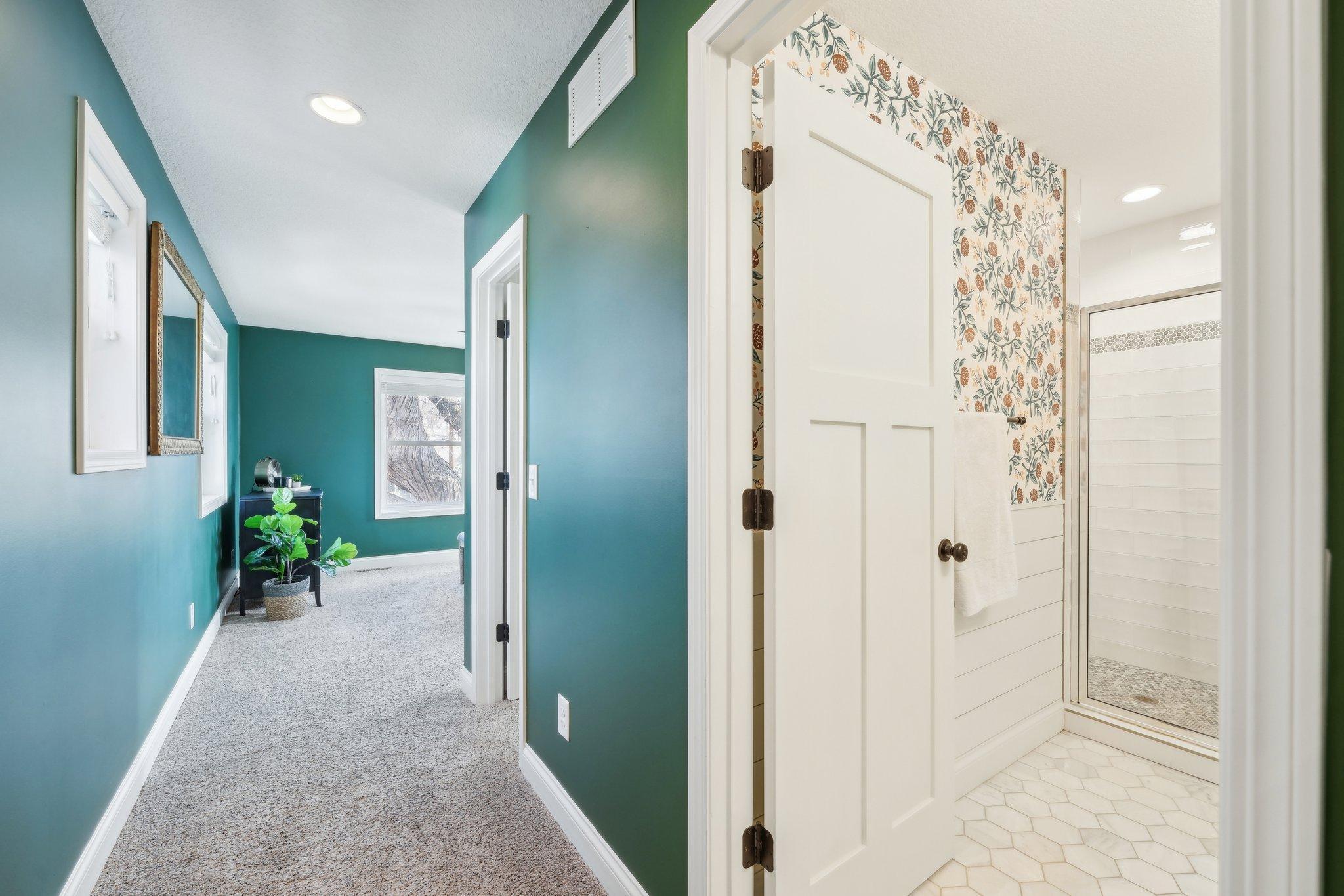 The thoughtful design of the primary suite separates the bedroom from the walk-in closet (center door) and the beautiful 3/4 private bathroom.