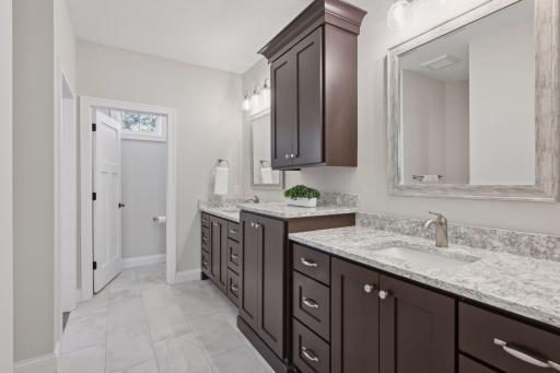 Primary bath offers double sinks and plenty of cabinetry for storage.
