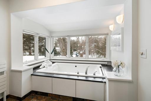Full primary bath overlooking lush backyard