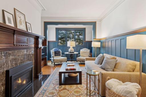 A cozy main level family room features a gas fireplace, plenty of seating, a tv niche and built-in library shelving.
