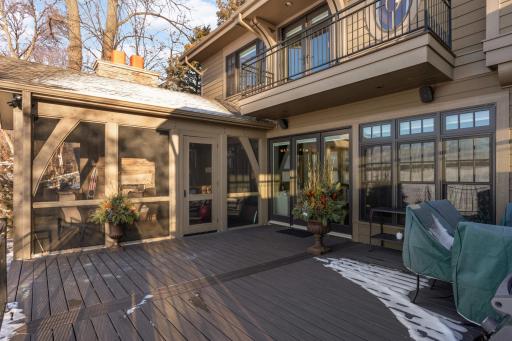 outside view of three season porch and deck. Triple doors lead to family room. Note the master deck above