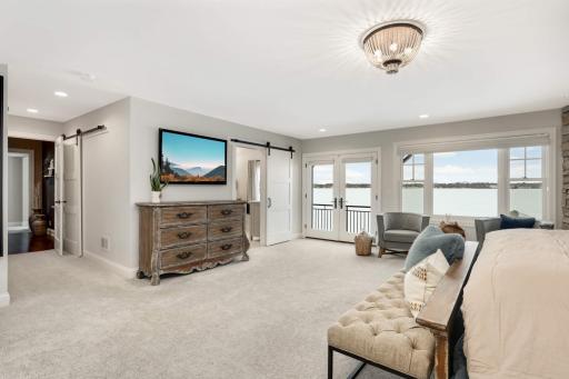 Pair of doors lead to the private master deck overlooking the lake