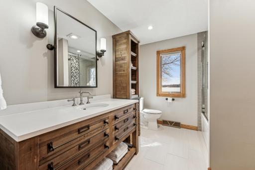 This is the main floor full bathroom with custom cabinets, tile floor and an amazing tile shower surround.