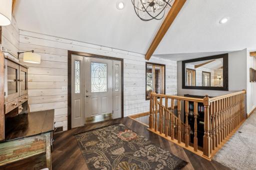 Bright, open, inviting entryway with weathered barn-wood look ship lap , vaulted ceilings and newer flooring.