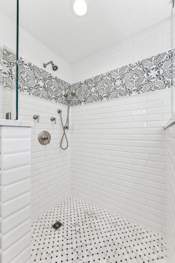This shower is incredible with its custom subway tile, accents, traditional shower head plus an additional shower wand.