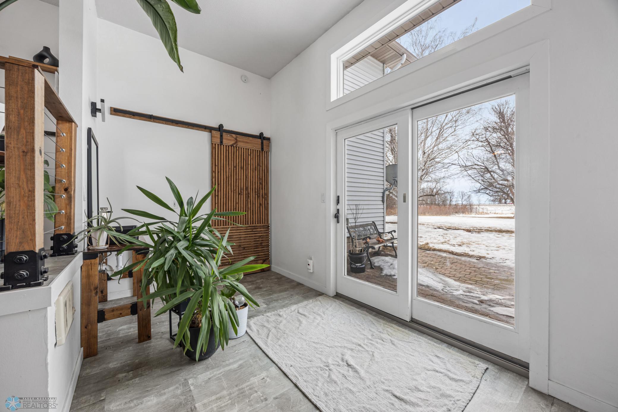 Patio Door to the exterior, potting/handwashing sink, and door to basement stairs