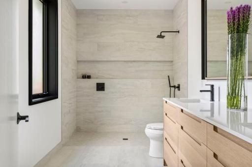 Primary bathroom. Floors have been waterproofed outside of the shower area if a future panel is desired versus door system