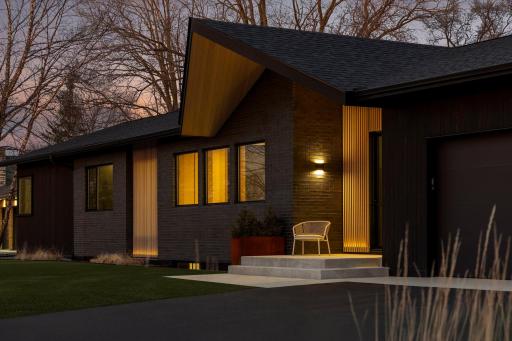 114 Burntside Dr front exterior. combination of Thermally modified pine, white-washed hemlock, white-washed cedar slats, and manganese ironspot full brick.