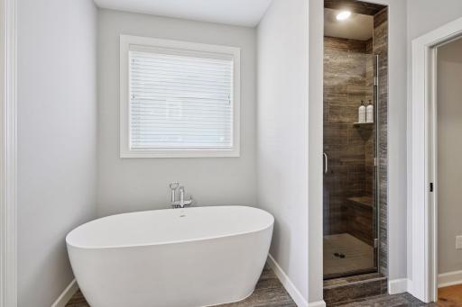 Soaking tub right next to the walk in shower in the primary suite