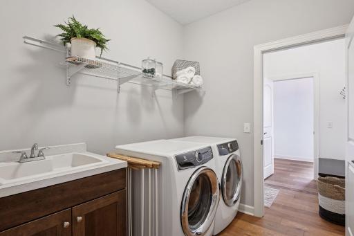 Main level laundry room located right off of the homes entrance and directly next to the primary suite walk in closet