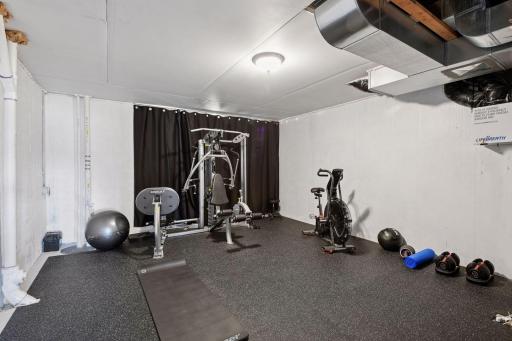 Large exercise room in the lower level. Keep it as a work out room or make it a craft room, the options are endless. Extra storage beyond the curtain