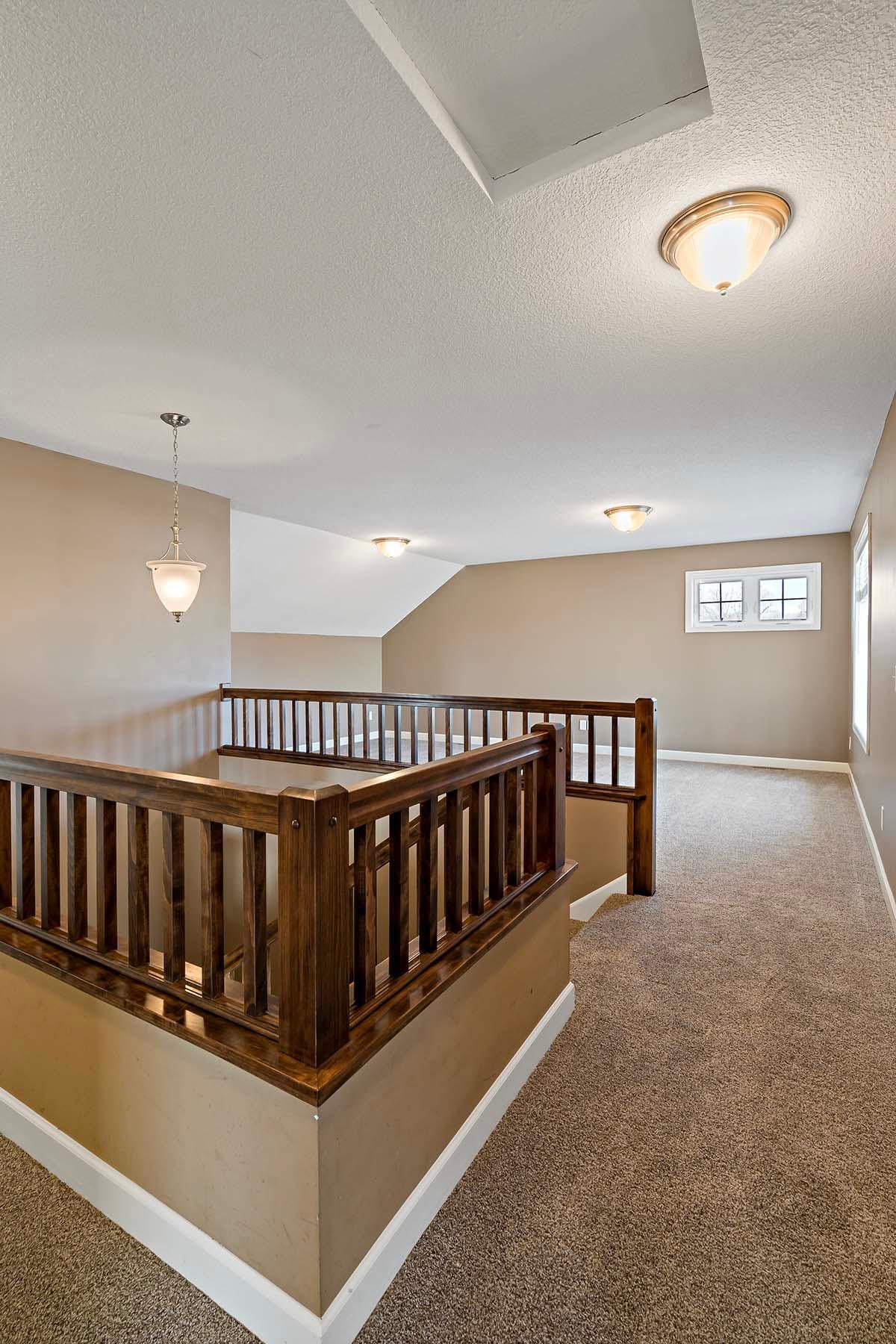 View of loft area. Bedrooms are to the right. Bathroom is behind you, Primary bed/bath are to the left.