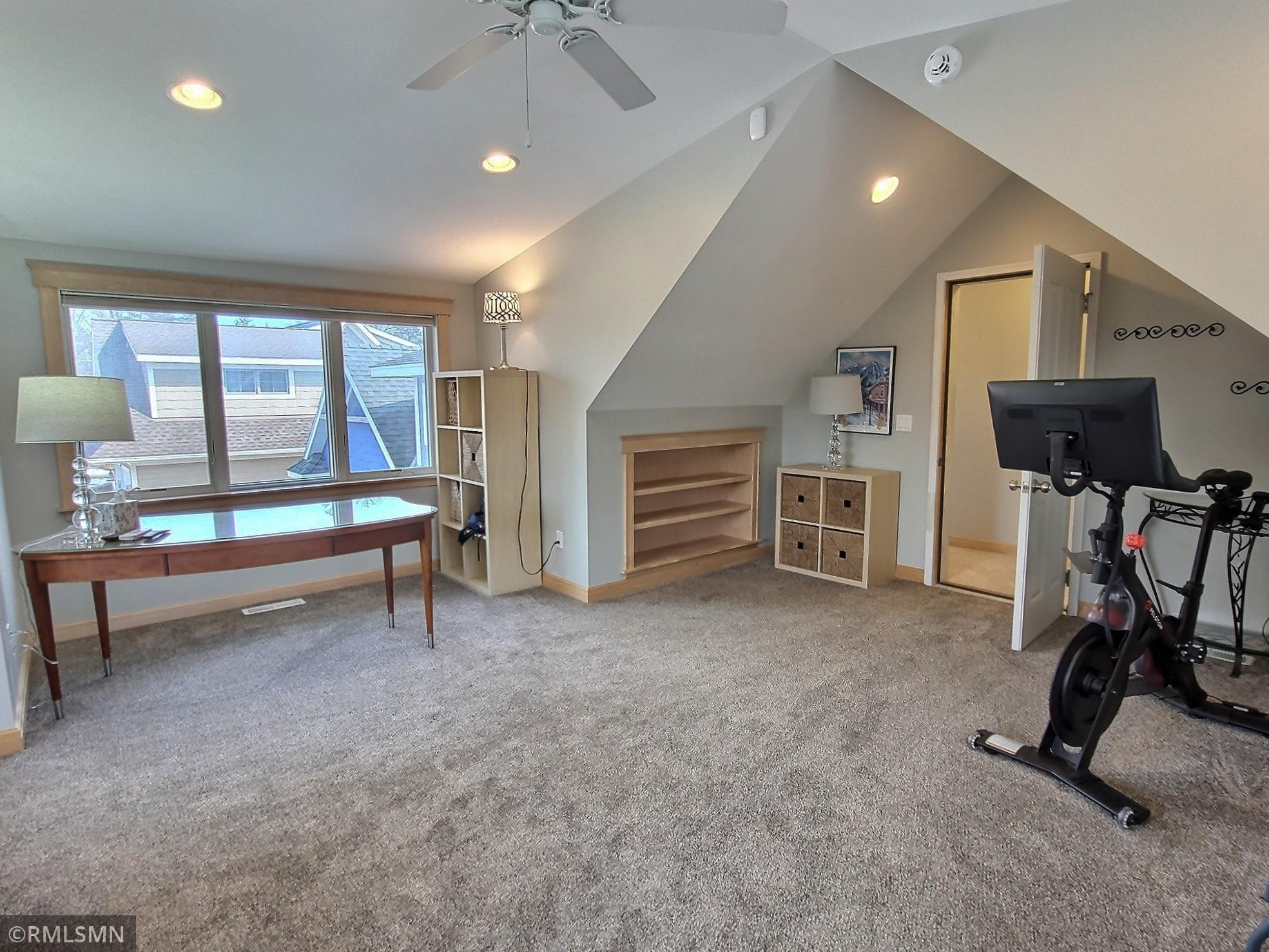 Above the garage is the flex room to be used in a variety of ways. As you will see the versatility of this room as it is currently used as home office, exercise area, sleeping quarters and TV viewing area. With still room to move around.