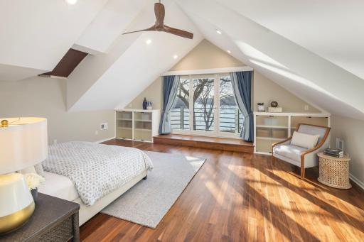 Primary owners suite with vaulted ceiling, private lakeside balcony, skylights, walk in closet with washer & dryer, and spa-like bathroom.
