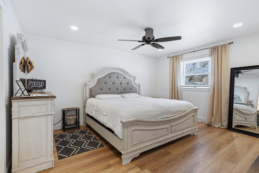 Wood flooring extends throughout much of the home, including the primary bedroom