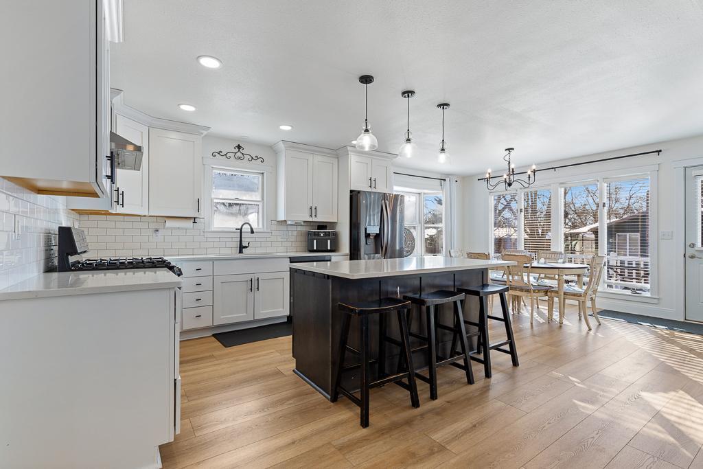 Fully updated in 2021-2022, this kitchen is an absolute dream. Bright white cabinets and tile backsplash compliment the dark, bold fixtures, wood flooring, and picturesque views of the outdoors