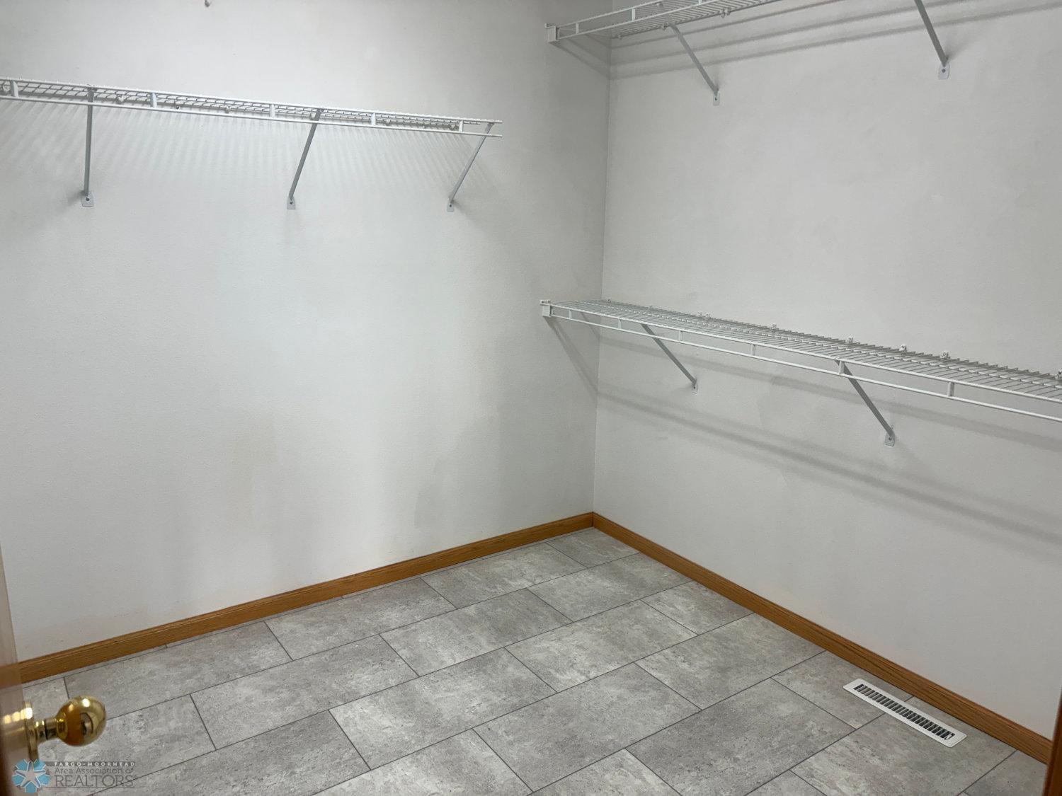 Master bedroom large walk-in closet with new vinyl flooring 2023-view 2.jpg
