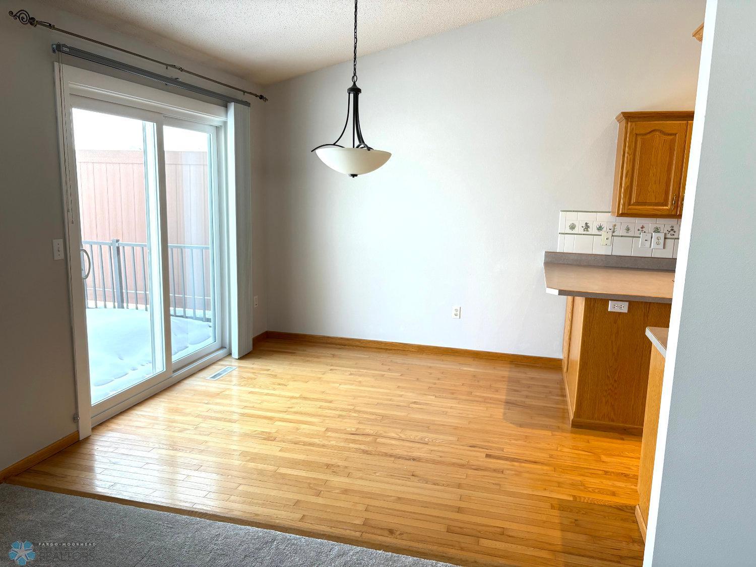 Dining area with solid oak floor; view toward patio door new in 2023.jpg