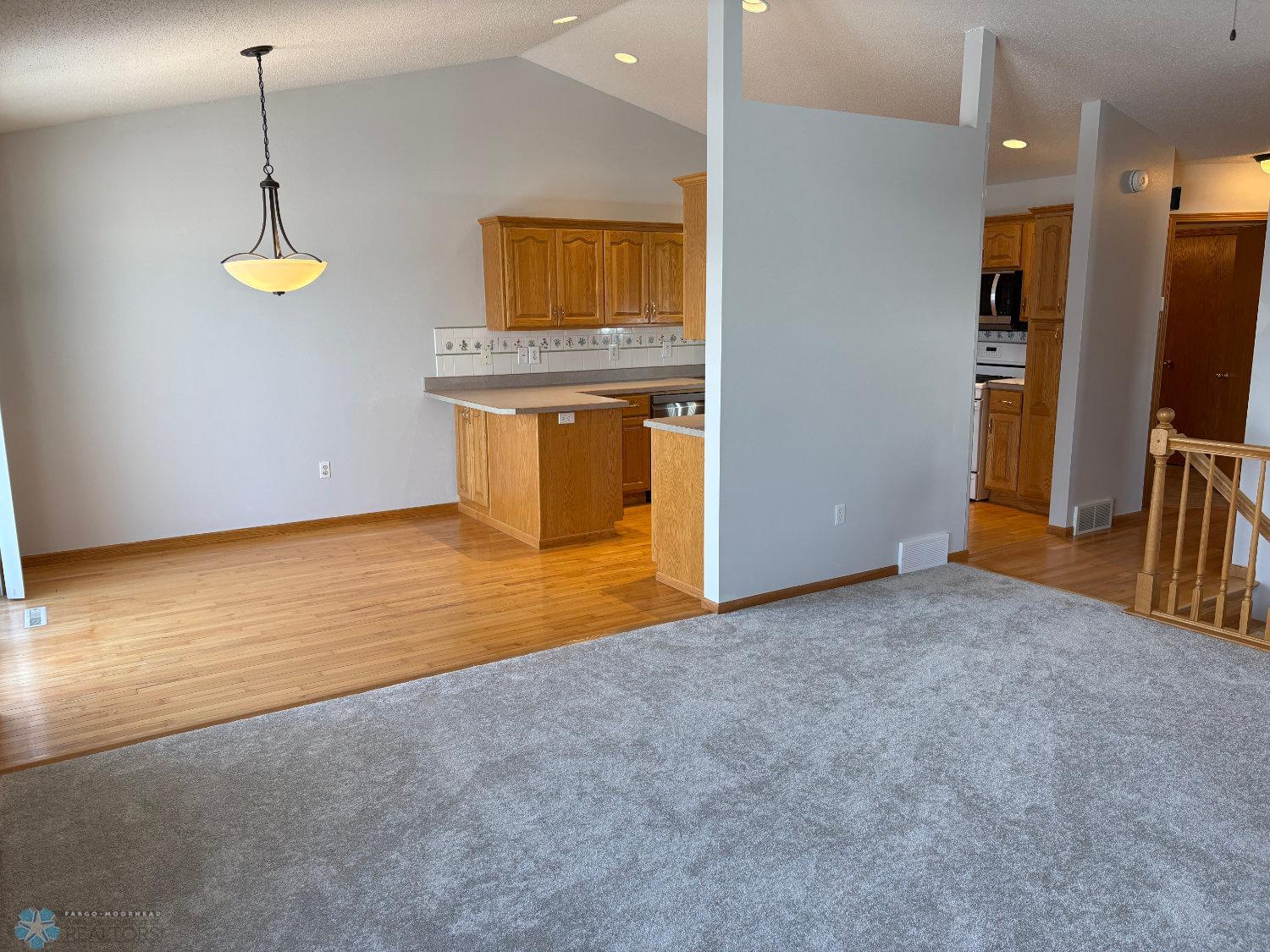 Vaulted living with new carpet February 2025-view to dining area and kitchen.jpg