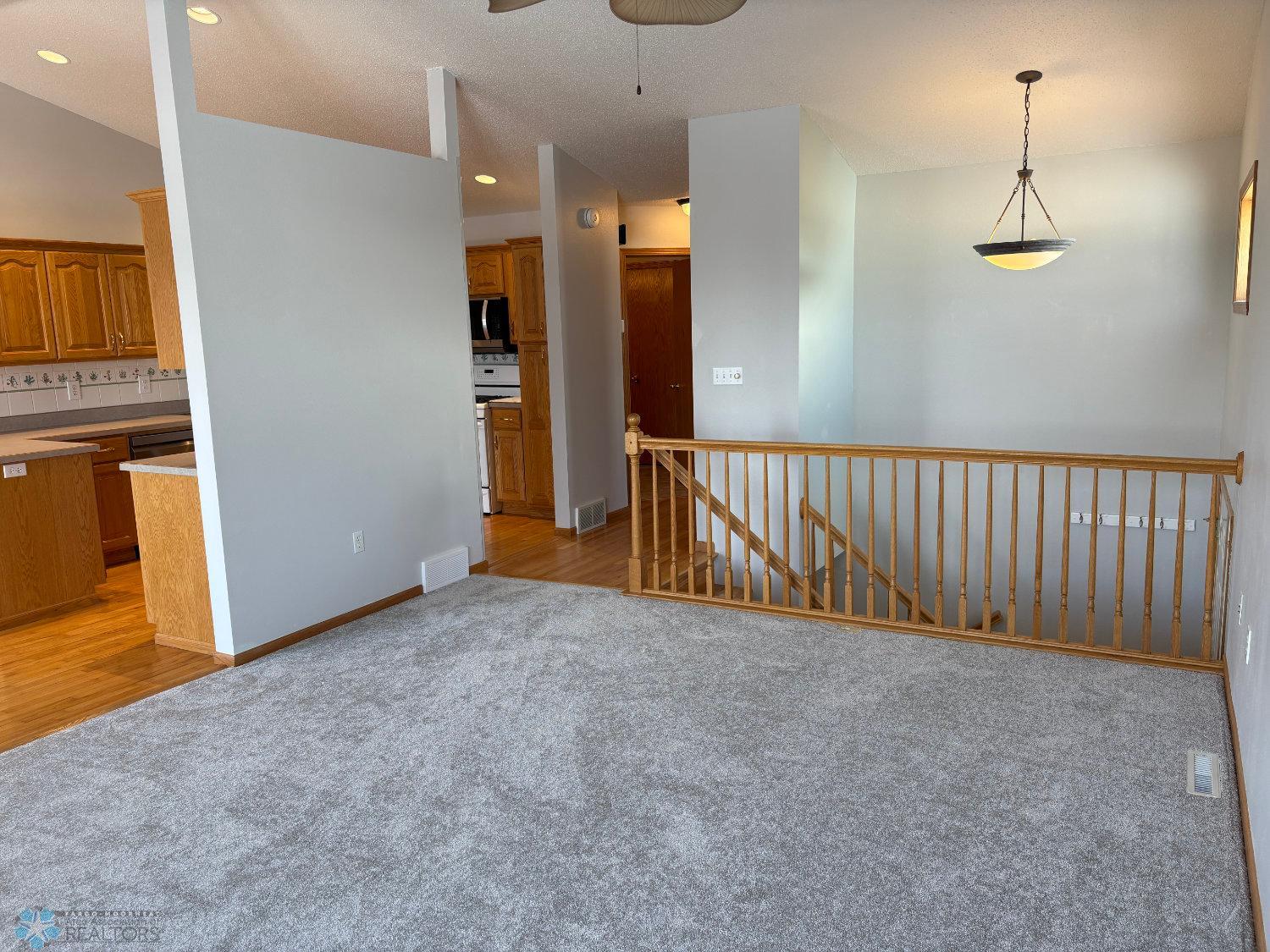 Vaulted living with new carpet February 2025-view toward stairway.jpg