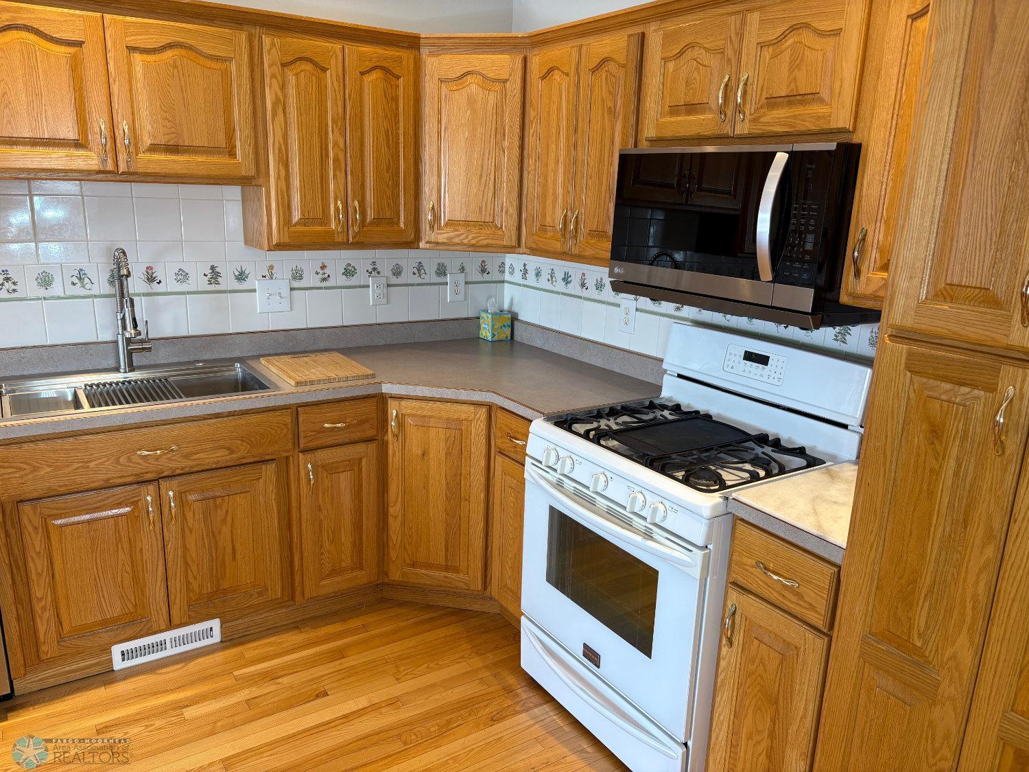 Kitchen view to gas range, microwave, and sink area.jpg
