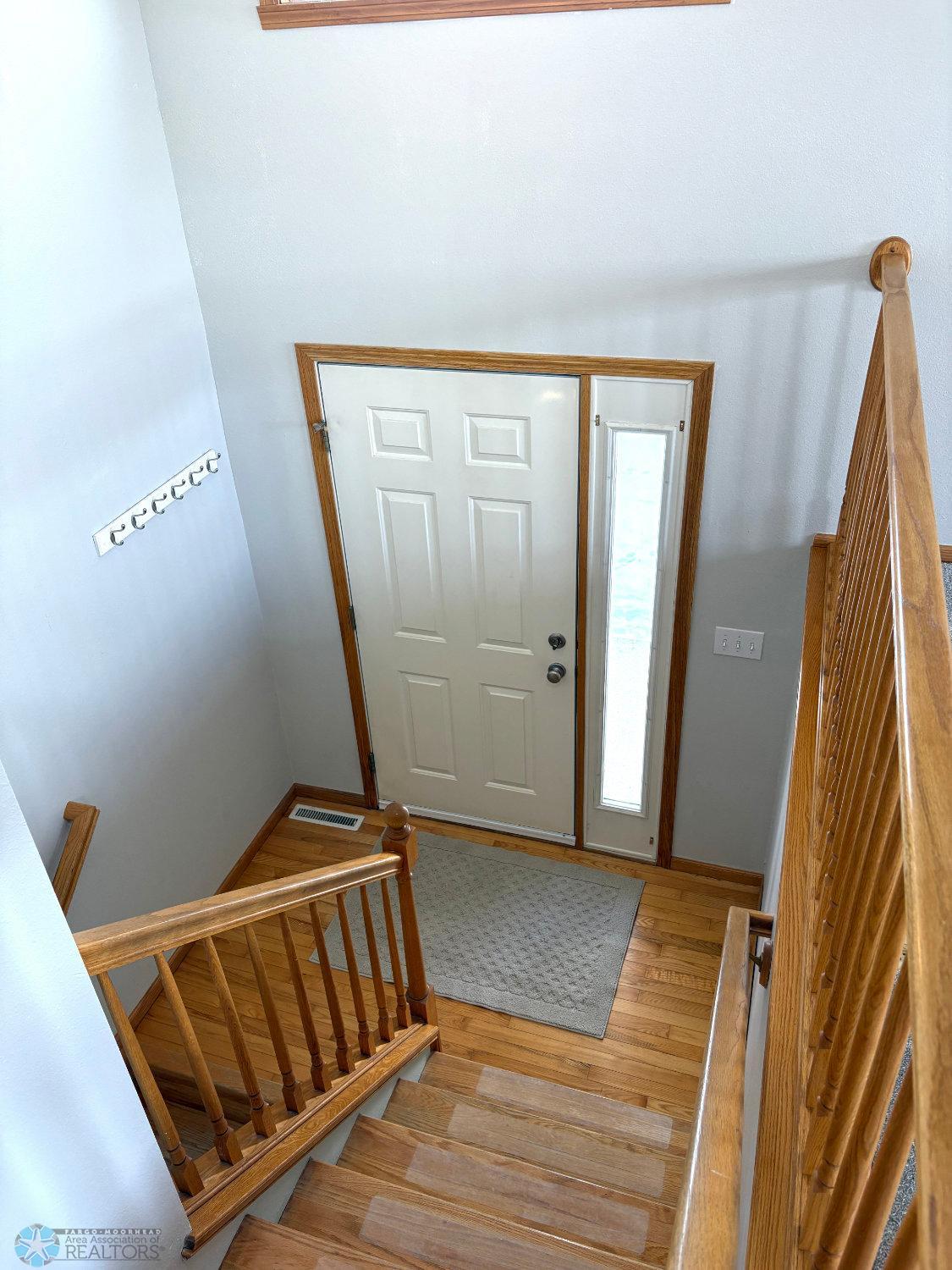 Foyer with solid oak floor and oak stair risers.jpg