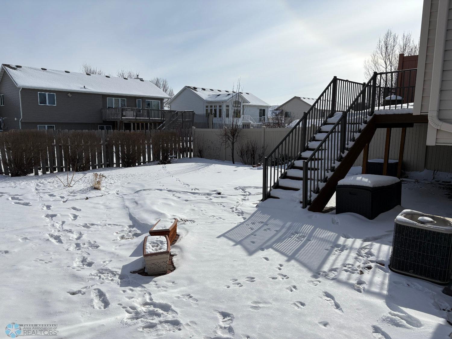 View to backyard and maintenance free deck new in 2023; large block patio under the snow.jpg