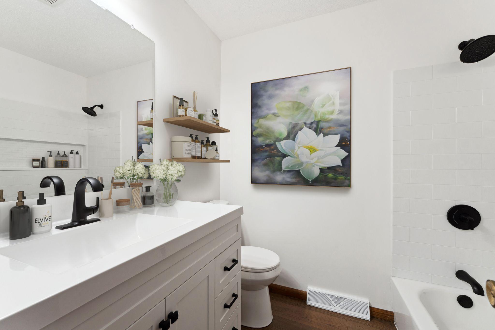 Virtually staged. Bathroom refreshed with brand new flooring, vanity, lighting, toilet, faucet, lighting and bathroom with shower.
