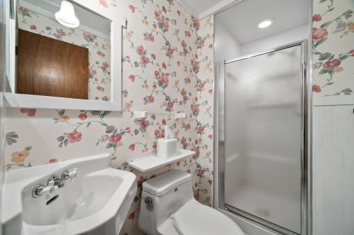 The lower level bathroom has a white-tiled floor.