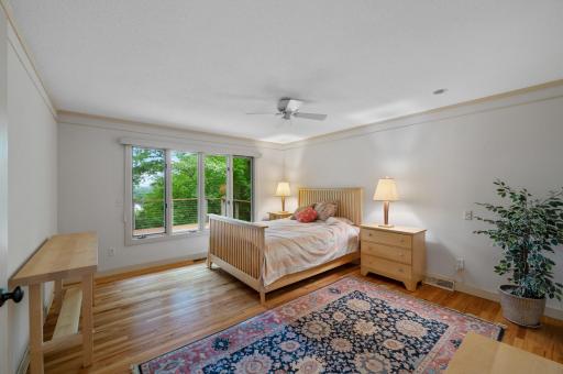 The main floor primary bedroom enjoys the views from the deck.