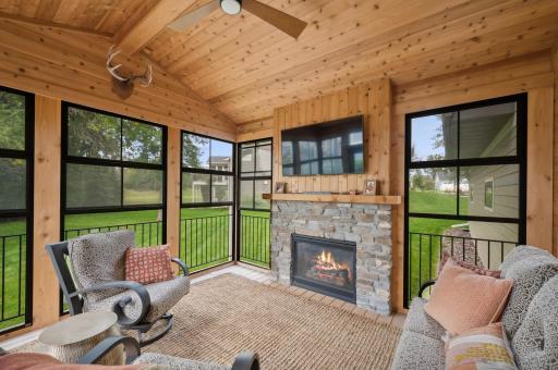 Step out onto the vaulted screened porch with a charming stone fireplace and take in the breathtaking views of the backyard. .jpg