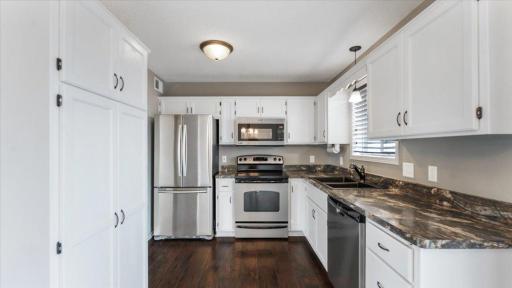 Kitchen features stainless steel appliances and engineered hardwood flooring.