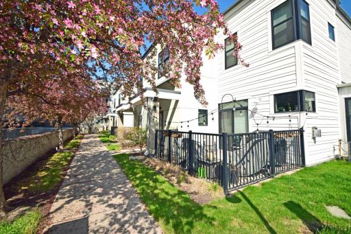 A tree lined walkway leads to the private front door and enclosed patio area.