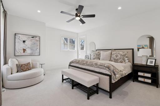 The primary suite offers a retreat on the main level boasting recessed lighting, a ceiling fan, speakers and primary bath.