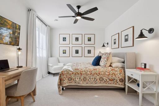 Bedroom #3 located in the lower level with carpet, ceiling fan with light and wall sconces.