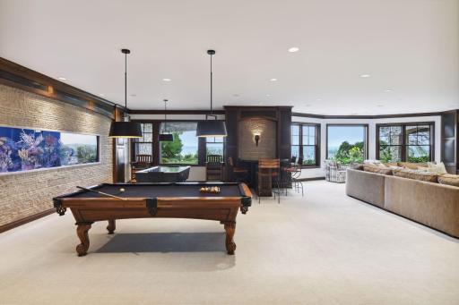 Retreat to the walkout lower level highlighting the family room with wet bar, guest bedroom suite, impressive fish tank, and sport court.