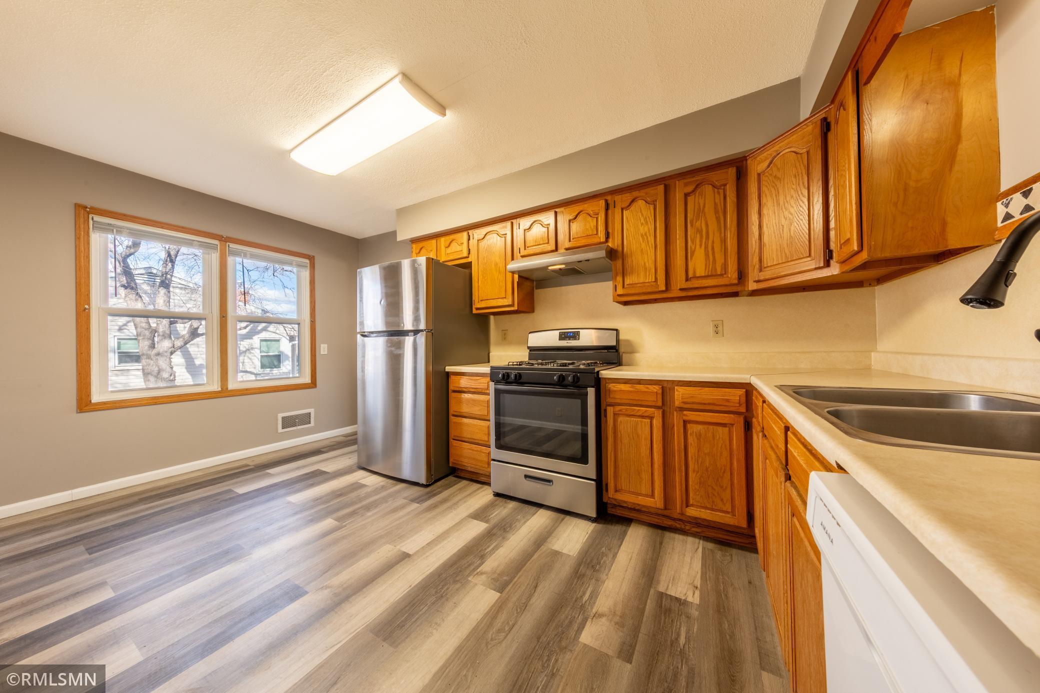 Kitchen is equipped with fridge, stove, and dishwasher