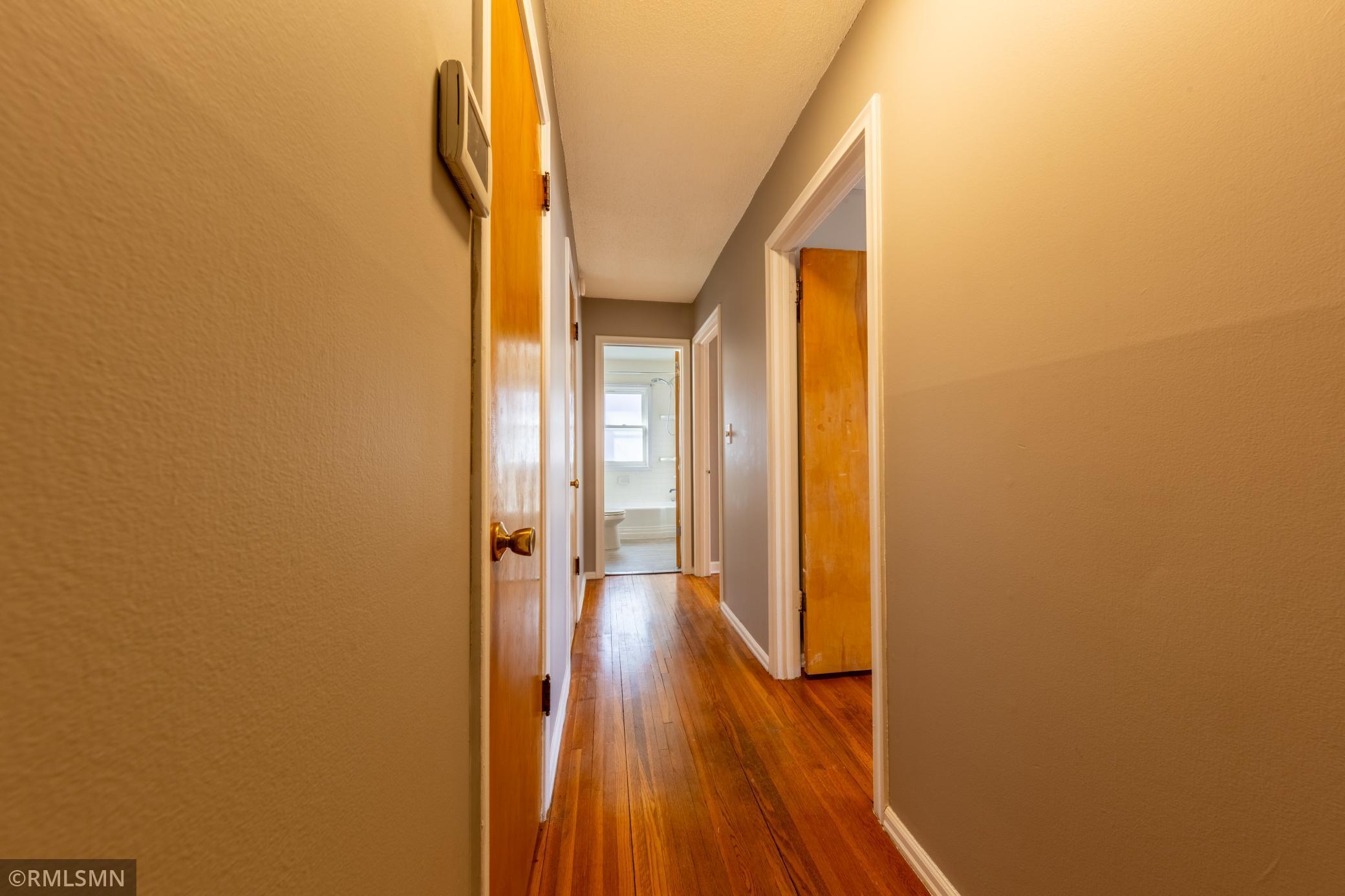 Hallway where you can find storage closets, a bathroom, and 2 bedrooms