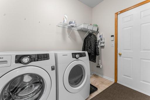 Laundry Room with Washer, Dryer, Hanging & Shelf Space plus Garage Access.