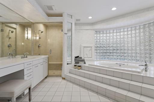 Primary bath with dual vanity areas, walk-in shower, and large whirlpool tub