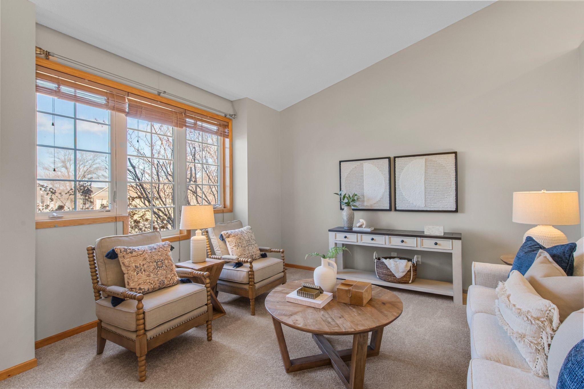 The living room, located on the main floor, is carpeted and front-facing, with a large window allowing natural light to flow in while offering peaceful neighborhood views.